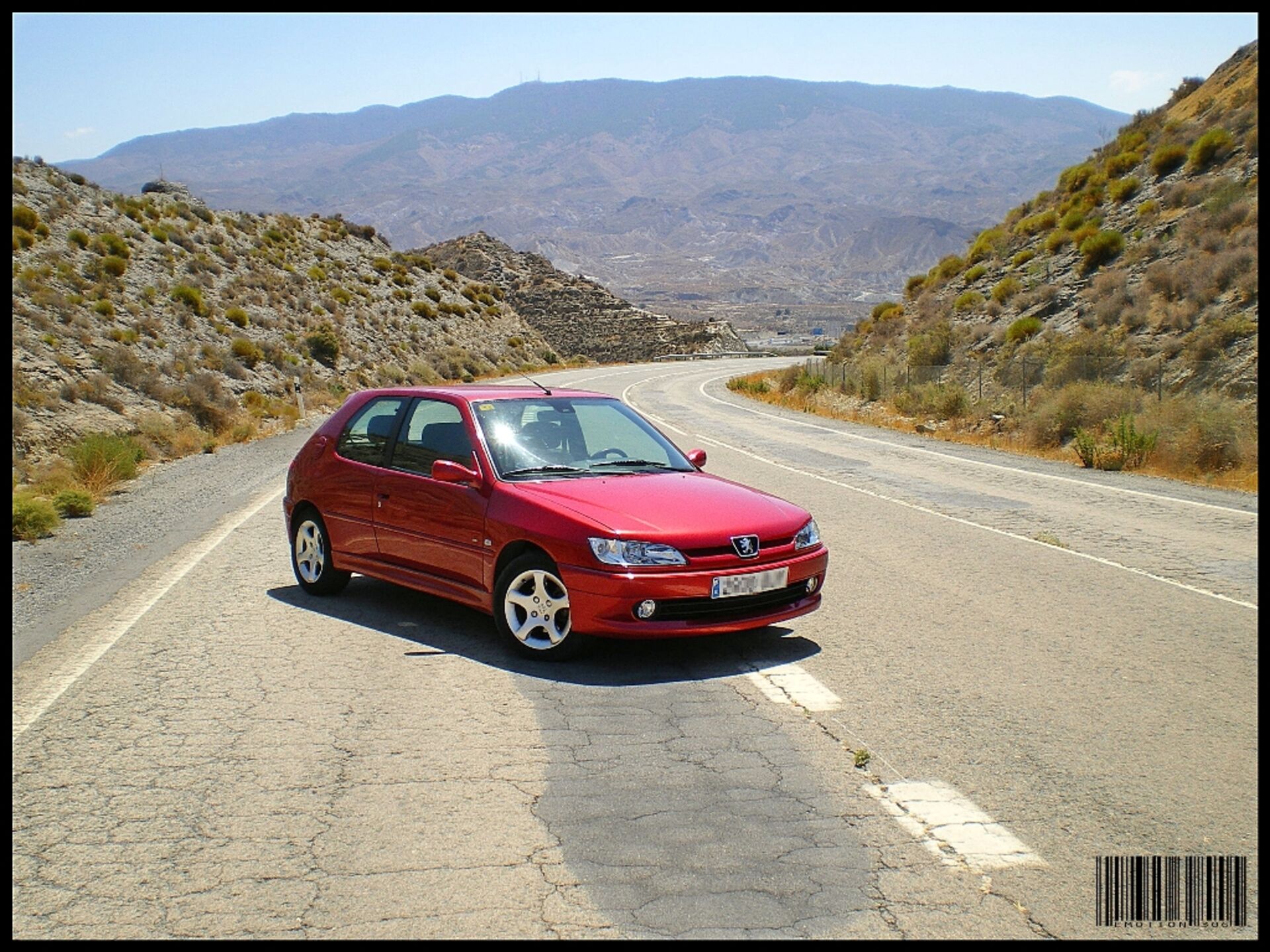 Peugeot 306 rojo en carretera de montaña